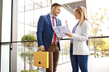 Genç iş adamları şirket bina ve yeni proje hakkında tartışmaya önünde rahatlatıcı.