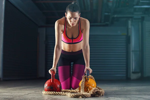 Young strong woman is training with kettlebell.