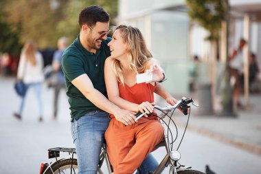 Şehir içinde Bisiklete binmek mutlu genç çift portresi.