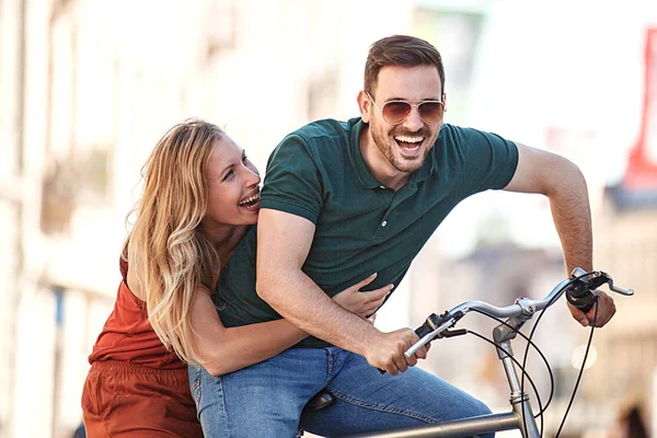 市内で自転車に乗って幸せな若いカップルの肖像画 — ストック写真
