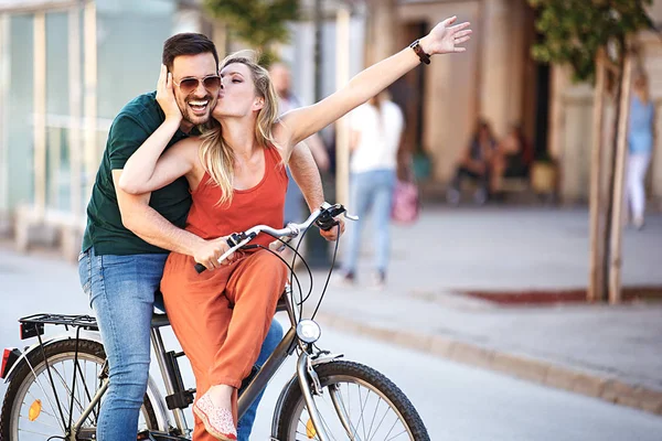 市内で自転車に乗って幸せな若いカップルの肖像画 — ストック写真