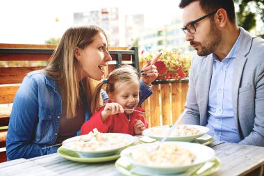 Mutlu bir aile restoranı makarna keyif alıyor.