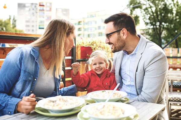 Happy family is enjoying pasta in restaurant.