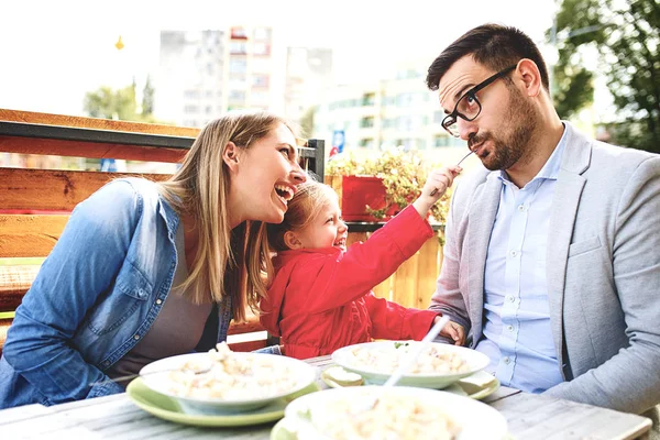 Mutlu bir aile restoranı makarna keyif alıyor.