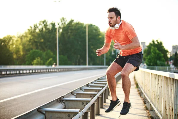 Yakışıklı delikanlı köprüde egzersizdir.