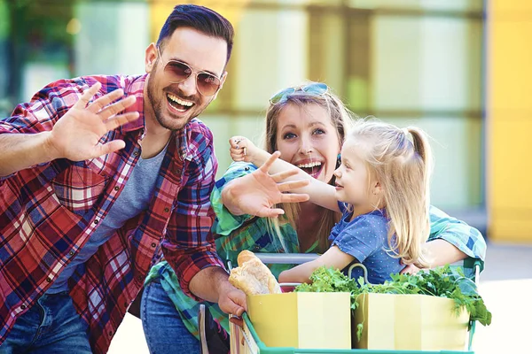 Giovani Genitori Sorridenti Loro Graziosa Figlia Con Carrello Pieno Cibo — Foto Stock