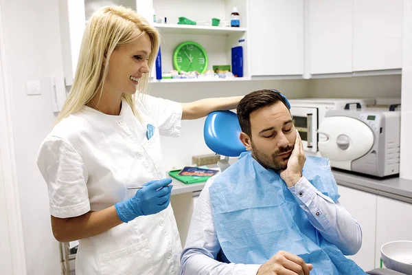 Kadın diş hekimi ve diş hekimi ofiste genç adam patinet.