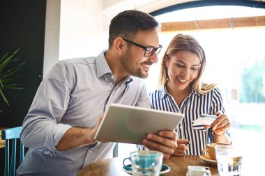 Genç çift tarafından tablet online alışveriş ve kahve zevk sahip.