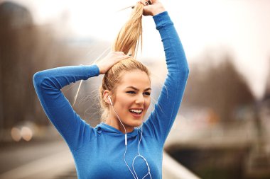 Genç kadın egzersiz Köprüsü ve müzik dinleme sonrası keyif alıyor.