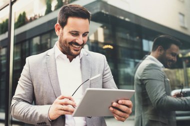 Genç gülümseyen işadamı dışında tablet kullanma.