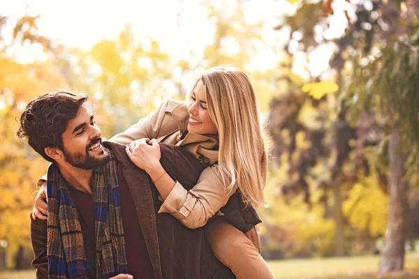 公園の若いカップルを楽しんで笑顔秋します — ストック写真
