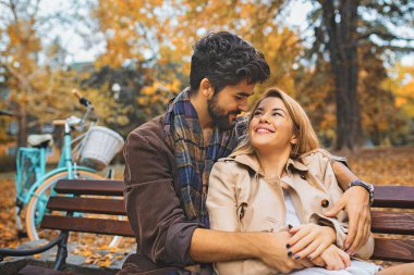 Genç çift zevk gülümseyen parkta düşmek.