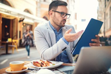 Genç işadamı kafede serbest işini yaparken.
