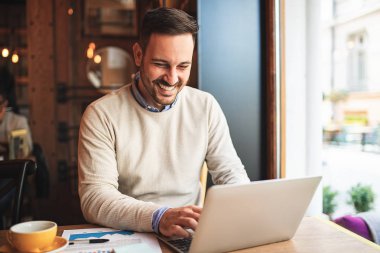 Genç işadamı kafede serbest işini yaparken.