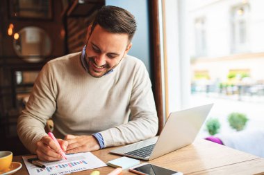 Genç işadamı kafede serbest işini yaparken.