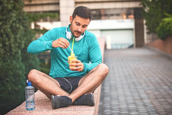 Young athlete man eating fruit after exercising.