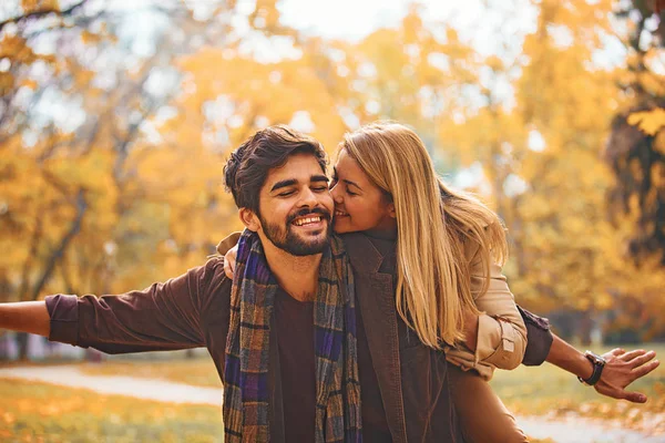 公園の若いカップルを楽しんで笑顔秋します — ストック写真
