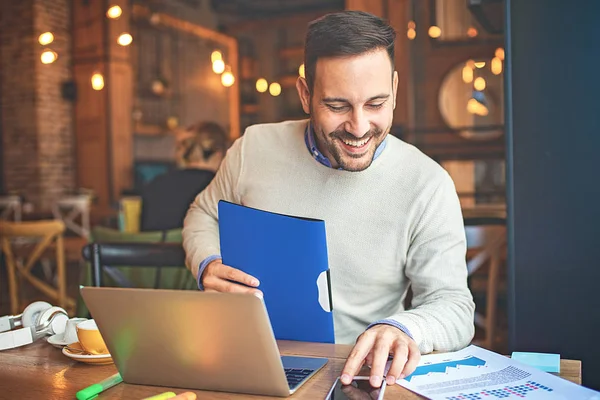 Genç işadamı kafede serbest işini yaparken.