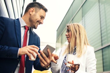 Genç iş adamları şirket bina ve yeni proje hakkında tartışmaya önünde rahatlatıcı.