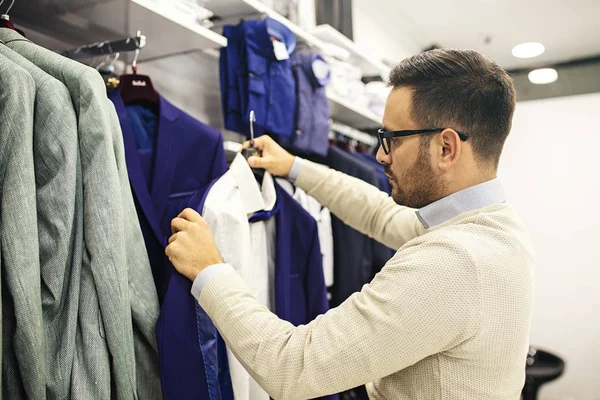 Handsome young man buying clothes in the store.