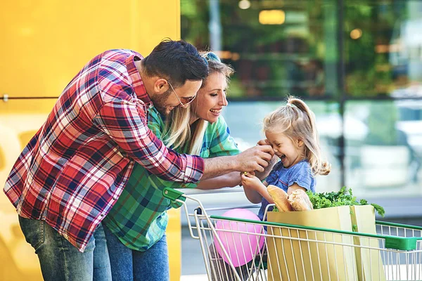 Junge Lächelnde Eltern Und Ihre Süße Tochter Mit Einem Einkaufswagen — Stockfoto