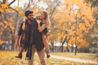 Genç çift zevk gülümseyen parkta düşmek.