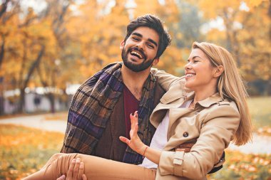 Genç çift zevk gülümseyen parkta düşmek.