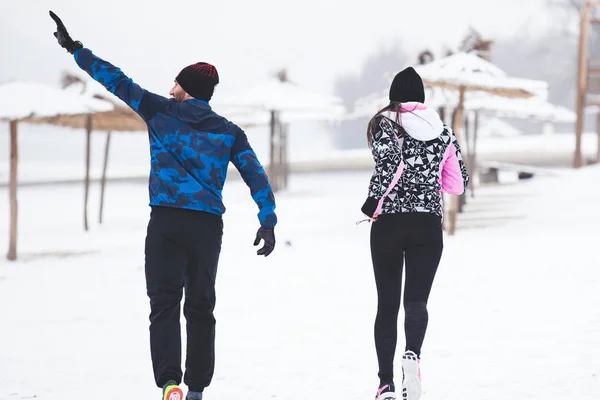 Young fit couple is exrcise on the snow.