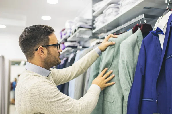 Smiling Young Man Buying Clothes Stock Photo by ©grki 172175736