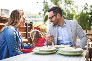 Mutlu bir aile restoranı makarna keyif alıyor.