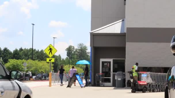 Pracownik Walmartu Zakłada Maskę Twarz Podczas Gdy Inny Współpracownik Wnosi — Wideo stockowe