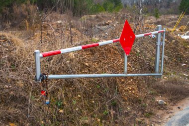 Kırmızılı bir güvenlik kapısı ve kilitler ıssız bir yolda açık. 
