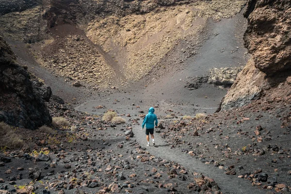 Człowiek Niebieskim Swetrze Wchodzi Krateru Wulkanu Cuervo Lanzarote Wyspy Kanaryjskie — Zdjęcie stockowe