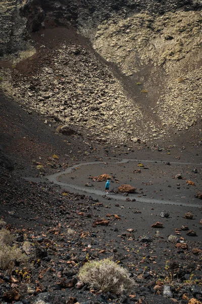 身穿蓝色毛衣的男子走在兰萨罗特市 埃尔奎沃 火山火山口内 加那利群岛 垂直照片 — 图库照片