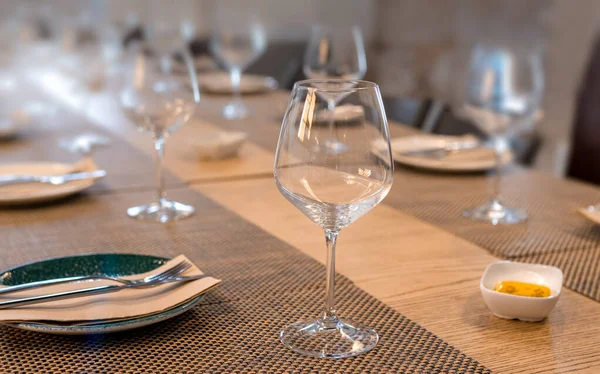 Bardakları ve çatal bıçakları olan birçok restoran masası.