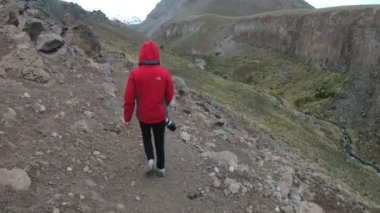 Büyük refelx kamerayla Vadisi yamaç peyzaj Domuyo volkan elinde üzerinde yürüyen kadın. Geisers ve arka plan üzerinde su buharı ile sıcak nehir. Neuquen, Patagonya Arjantin