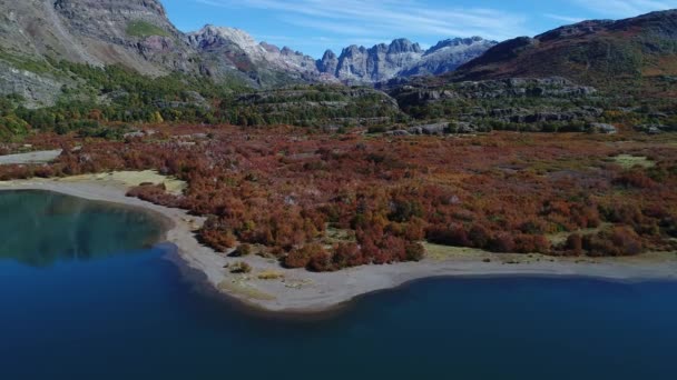 バック グラウンドで アンデス山脈の大きなロッキー山脈 Epu Lauquen ラグーン 山にコストから前方と上方を移動空中ドローン シーン Mirros として湖 — ストック動画