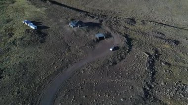 Terk edilmiş binalar ve wilde bozkır orta evlerde. Tromen Milli Park, bir römork ile Patagonya Arjantin van. Yukarıdan aşağıya doğru hareket, hava uçak sahne. Günbatımı altın saat