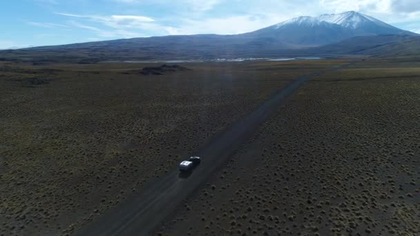 面包车和拖车 旅宿汽车在巴塔哥尼亚阿根廷骑在砾石偏僻的道路上 怀勒山上有雪和拉根的背景 国家公园 空中无人机现场移动右跟踪车 — 图库视频影像