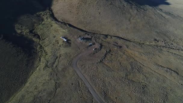 放棄された建物や住宅 Tromen 国立公園 ネウケン アルゼンチン パタゴニアでワイルド草原のまっただ中 空中ドローン上面 下方向に移動のシーン 黄金の夕日の時間 — ストック動画
