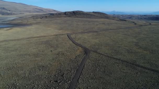 Letecká drone scéně prázdné silnice štěrk. Kamerou pohybující se vpřed. Estepa tromen národní park, chos malal, neuquen, patagonia argentina.