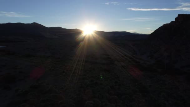 空中ドローン シーン バランカス川風の強い日で サンセット ゴールデンの時間でバックライトします ネウケン アルゼンチンのメンドーサの分割状態 カメラの後方に移動し ダウン 山の後ろの太陽 — ストック動画
