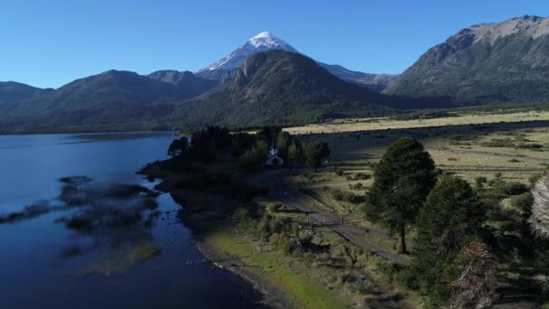 空中无人机场面山 Estepa 照相机从 Paimun 湖向前移动到 Lanin 与尘土路 汽车跟踪和停车场和一个教堂 内乌肯省 巴塔哥尼亚 — 图库视频影像