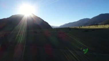 Hava dron sahne dağlar, ağaçlar ve günbatımında güneş ray, ileri ve göl kadar hareketli Piedra Mala, Neuquen, Patagonia, Arjantin kamera ile estepa