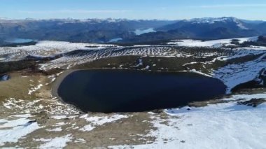 Villa Pehuenia karlı Batea Mahuida volkan hava dron sahne. Kamera krater ve lagün üzerinde geriye doğru arka plan lake Alumine ve Moquehue hareket eder. Neuquen, Patagonya Arjantin.
