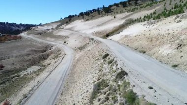 Kamyonet ve karavan Litran Nehri vadisinde bir çakıl yolda seyahat hava dron sahne. Renkli Sonbahar bitki örtüsü. Hala araba yolda seyahat ederken kamera kalır. Villa Pehuenia - Moquehue. Patagonya Arjantin. 