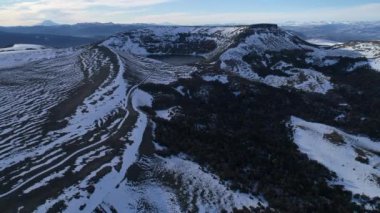 Villa Pehuenia'Batea Mahuida yanardağ hava dron sahne. Kamera yükselir sahip tüm krater ve lagün manzarasına. Karlı dağlar, renkli woods arka plan. Neuquen, Patagonya Arjantin.