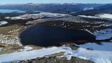 Villa Pehuenia hava dron sahne karlı Batea Mahuida volkan. Kamera krater ve lagün üzerinde geriye doğru krater sınırın, göl Alumine ve Moquehue Neuquen Patagonya Arjantin arka plan seyahat