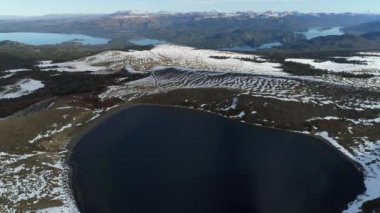 Villa Pehuenia karlı Batea Mahuida volkan hava dron sahne. Kamera krater ve lagün, göl Alumine ve Moquehue ve karlı Dağları'nın arka plan üzerine. Neuquen, Patagonya Arjantin.