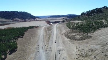 Kamyonet ve karavan Litran Nehri vadisinde bir çakıl yolda seyahat hava dron sahne. Sonbahar bitki örtüsü. Kamera çok yüksek noktasıyla başlar, yavaş yavaş araba aşağıdaki azalan seyahat eder. Villa Pehuenia
